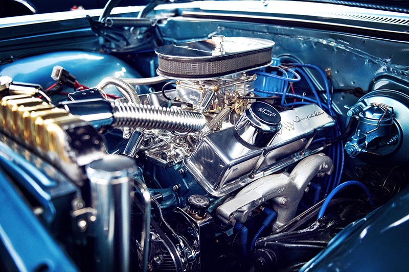 A classic snapshot of a classic car under the hood which includes high end vintage car parts