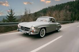 a picture of the190SL Mercedes zipping through a beautiful country road